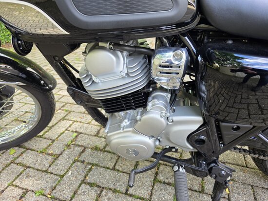 Detailaufnahme von Motor, Fahrwerk und Bremsen einer modernen Retro-Maschine